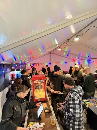 Fyldt hal med kunder ved baren og popcornmaskinen