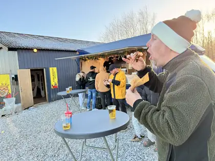Kunde nyder en flæskestegssandwich fra Gourmet Vognen